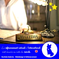 plaque "réception" d'un hotel posé sur un comptoir en bois